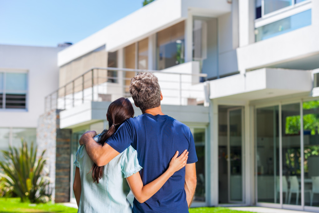 couple embracing in front of new modern home